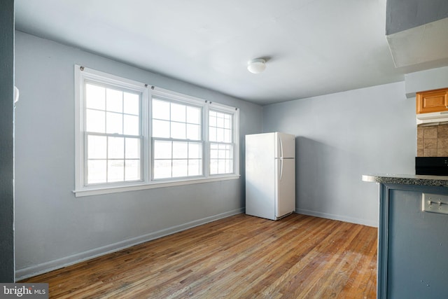 kitchen with decorative backsplash, dishwasher, light hardwood / wood-style floors, and white refrigerator