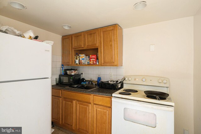 kitchen with decorative backsplash, light tile patterned floors, white appliances, and sink