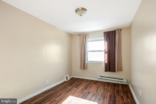 spare room featuring dark hardwood / wood-style floors and a baseboard heating unit