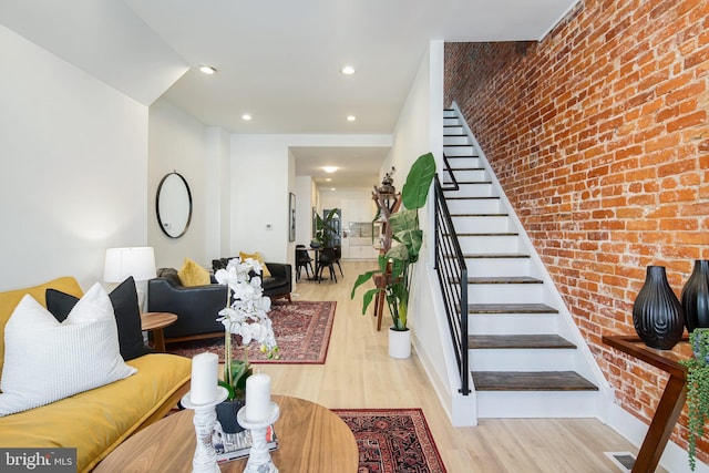 interior space with brick wall and hardwood / wood-style flooring