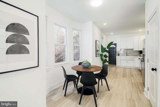 dining space featuring sink and light hardwood / wood-style flooring