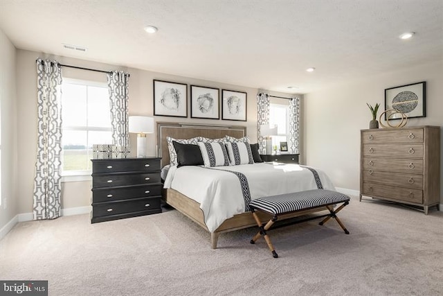 carpeted bedroom featuring multiple windows