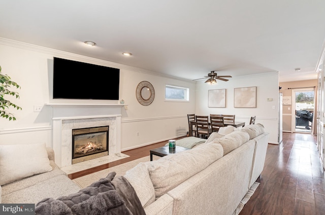 living room featuring ceiling fan, crown molding, and a high end fireplace