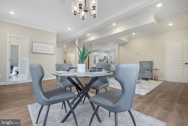 dining room featuring light hardwood / wood-style floors, an inviting chandelier, and ornamental molding