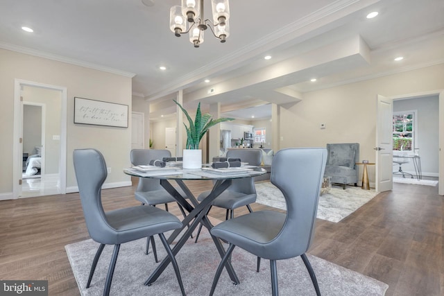 dining room with ornamental molding, hardwood / wood-style flooring, and a notable chandelier