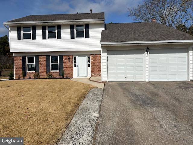 view of front of home with a garage and a front lawn