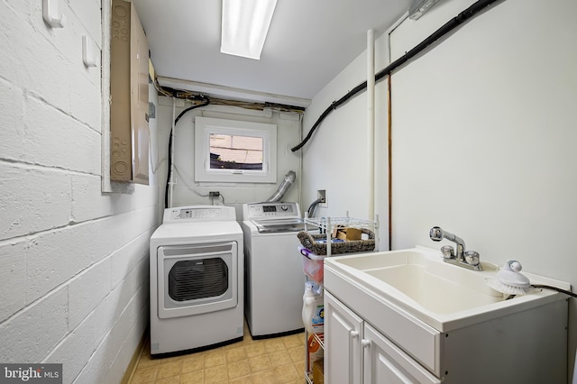 laundry room with washing machine and dryer, a sink, and cabinet space