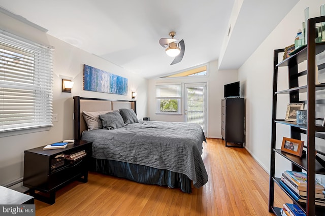 bedroom with a ceiling fan, light wood-type flooring, vaulted ceiling, and baseboard heating