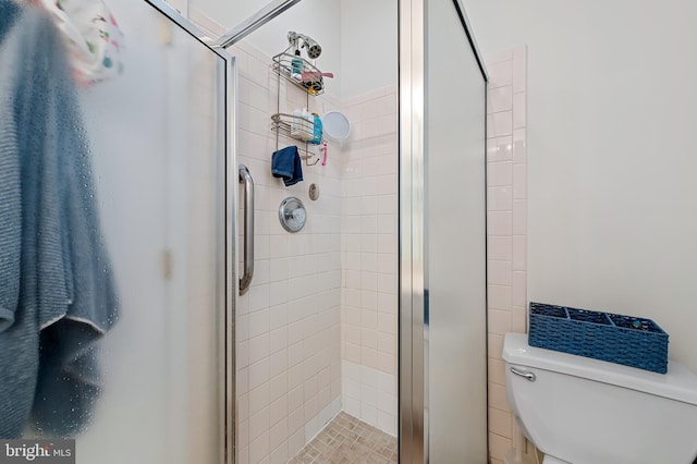 full bathroom featuring a stall shower and toilet