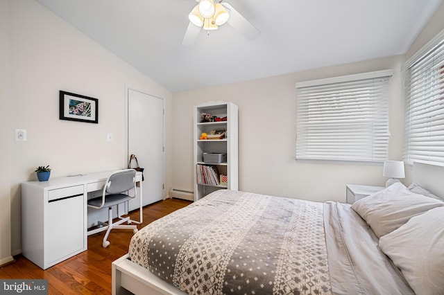 bedroom featuring ceiling fan, a baseboard heating unit, vaulted ceiling, and wood finished floors