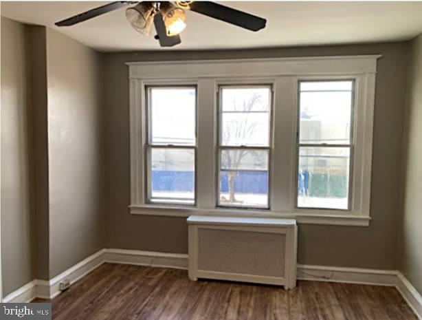 unfurnished room with a wealth of natural light and dark hardwood / wood-style floors