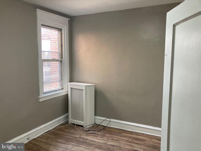 spare room featuring plenty of natural light and hardwood / wood-style floors