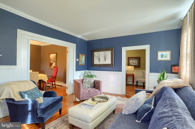 living room featuring hardwood / wood-style floors, a baseboard radiator, and crown molding