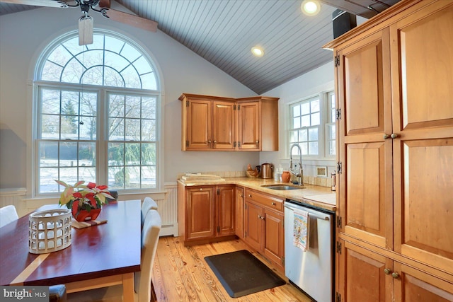 kitchen with dishwasher, sink, baseboard heating, lofted ceiling, and light wood-type flooring