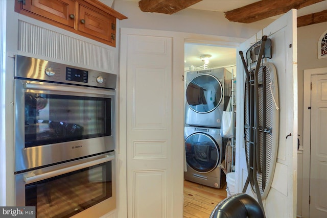 laundry area with light wood-type flooring and stacked washing maching and dryer