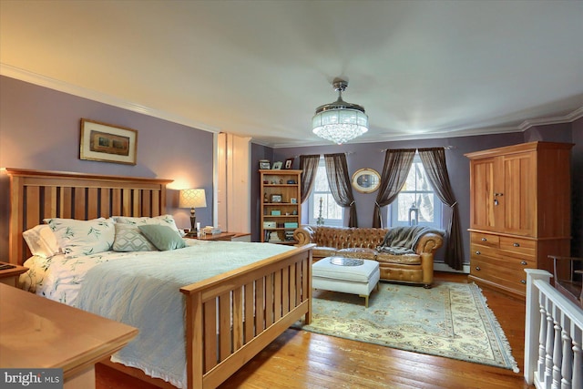 bedroom with light hardwood / wood-style floors and ornamental molding