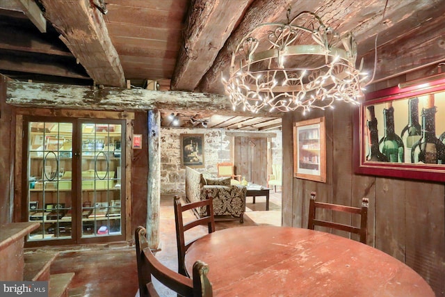 dining area featuring beamed ceiling, wooden ceiling, and wooden walls