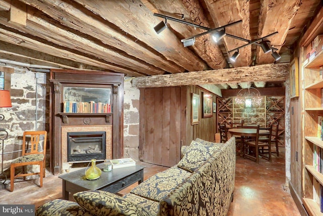 living room with beam ceiling and wood walls