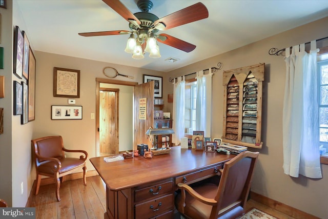 home office featuring light hardwood / wood-style flooring, plenty of natural light, and ceiling fan