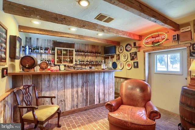 bar with beamed ceiling and wood walls