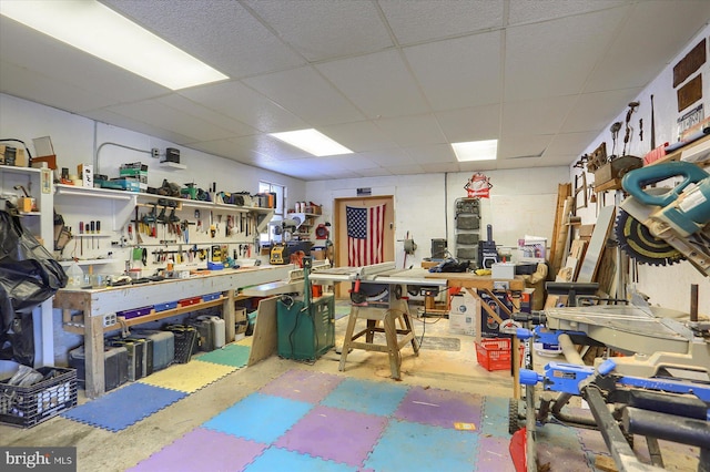 misc room featuring a workshop area and a drop ceiling