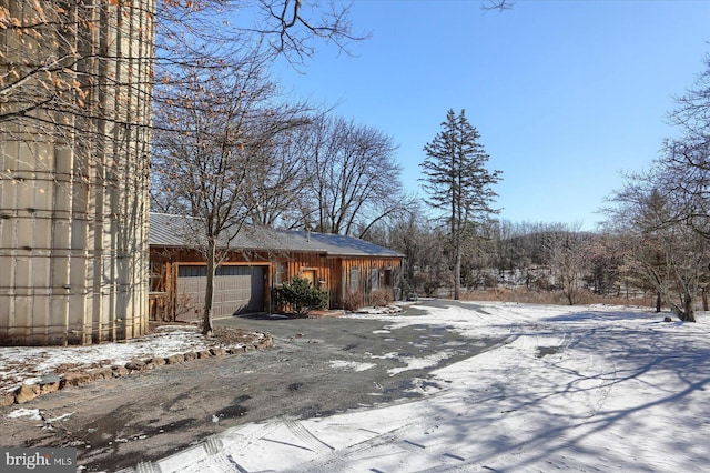 view of snowy exterior featuring a garage