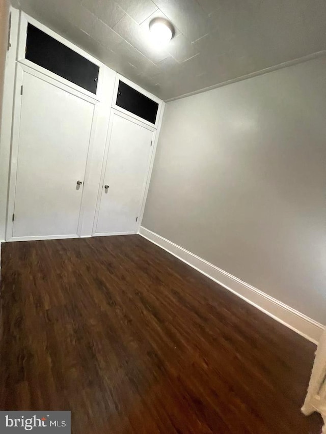 unfurnished bedroom featuring dark wood-type flooring and a closet