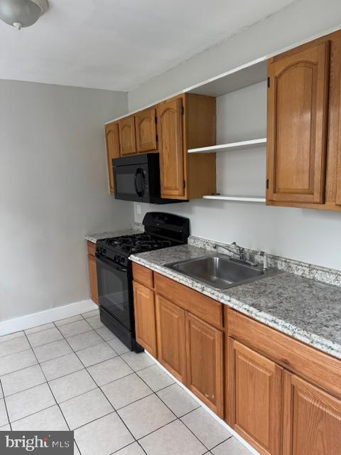 kitchen with sink, light tile patterned flooring, and black appliances