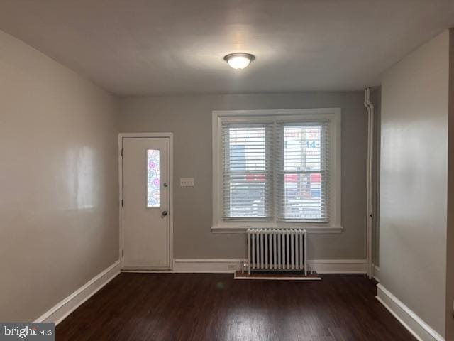 entryway featuring dark wood-type flooring and radiator