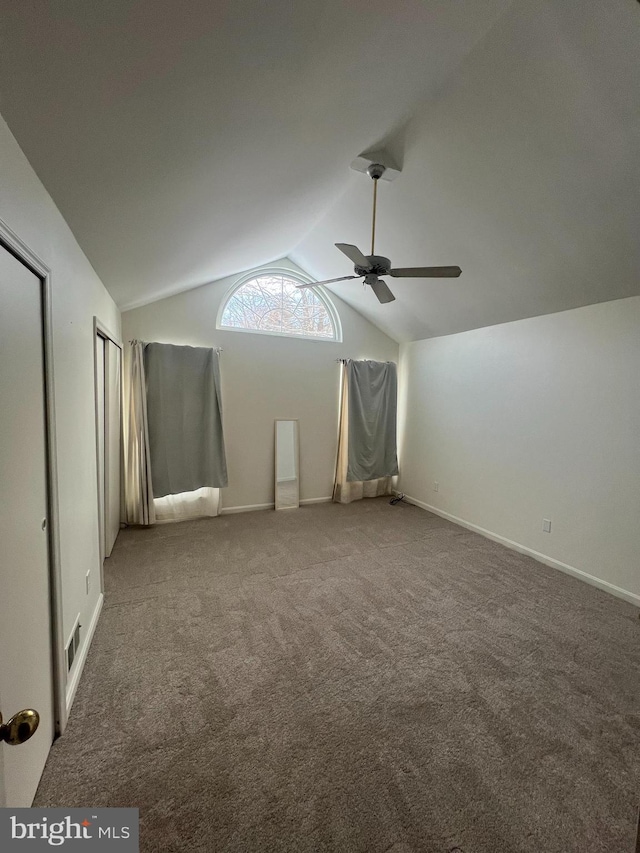 interior space featuring ceiling fan, carpet floors, and vaulted ceiling