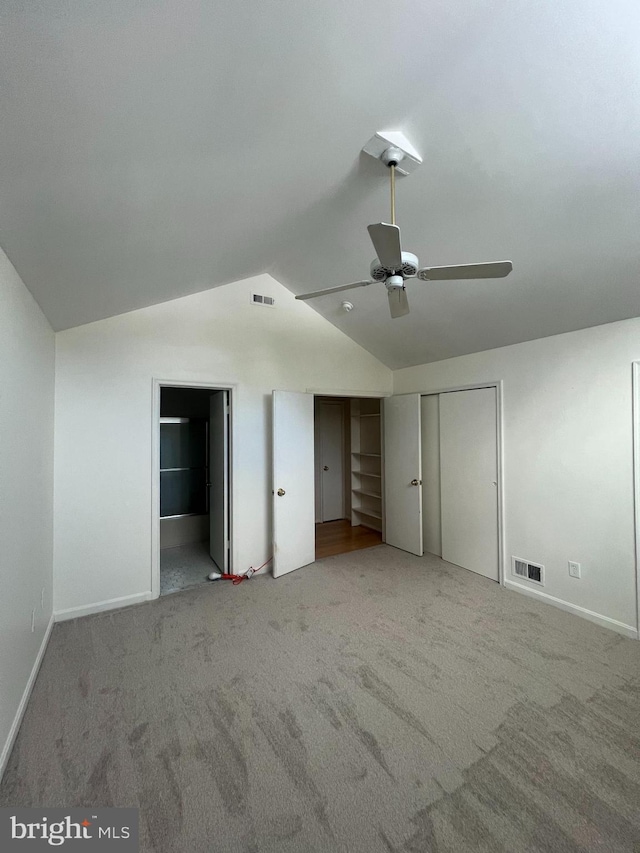 unfurnished bedroom featuring carpet floors, vaulted ceiling, and ceiling fan