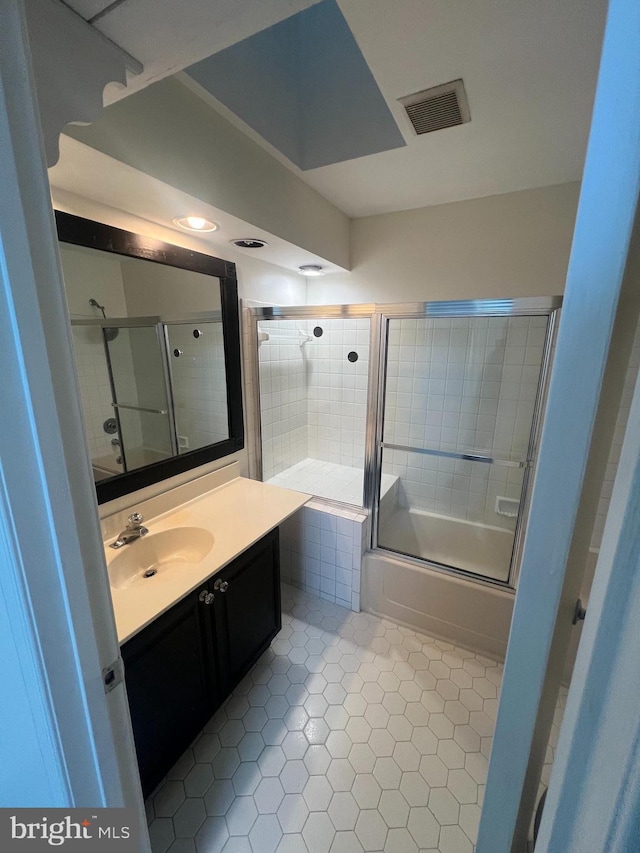 bathroom with combined bath / shower with glass door, vanity, and tile patterned floors