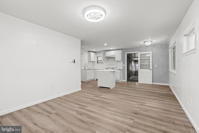 unfurnished living room featuring sink and light hardwood / wood-style flooring