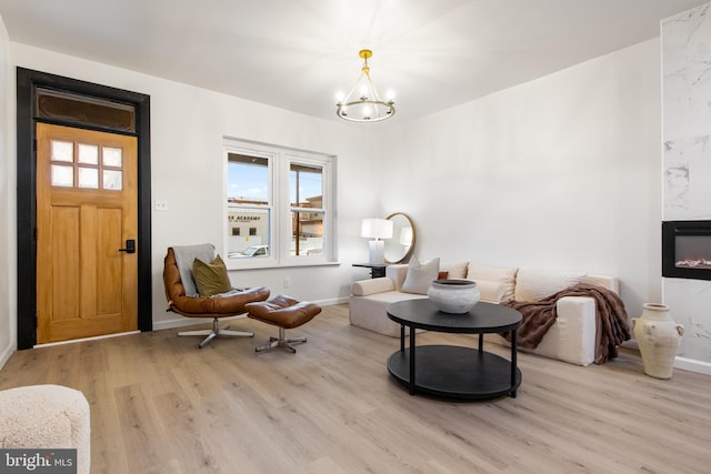 living area with light wood-type flooring and an inviting chandelier