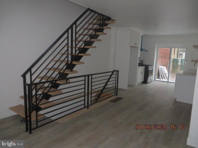 stairs featuring hardwood / wood-style floors and sink