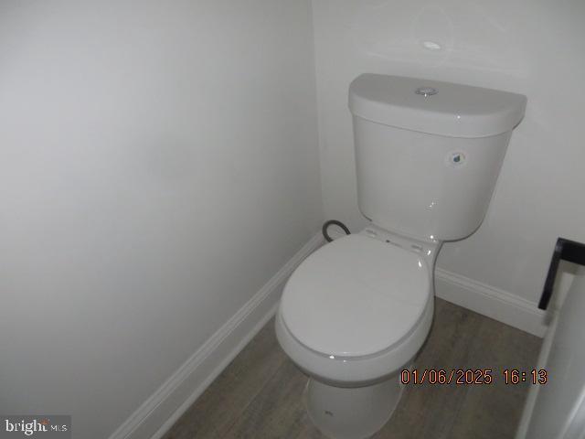 bathroom featuring hardwood / wood-style flooring and toilet