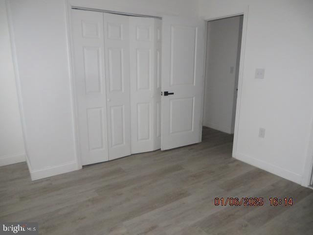 unfurnished bedroom featuring light wood-type flooring and a closet