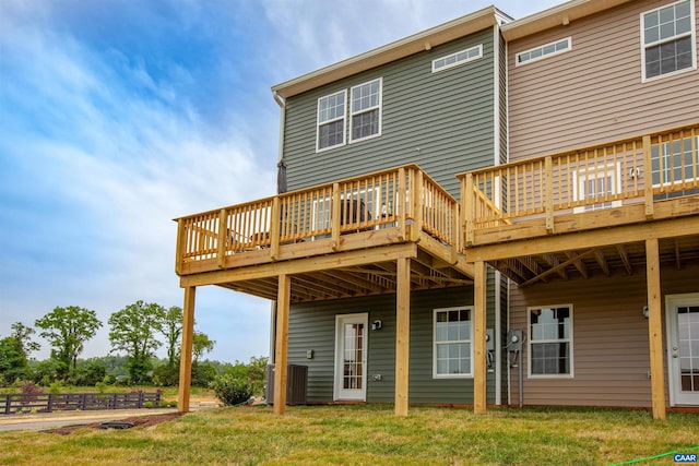 back of house featuring a lawn, a wooden deck, and central AC