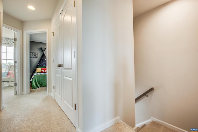 hallway featuring light colored carpet