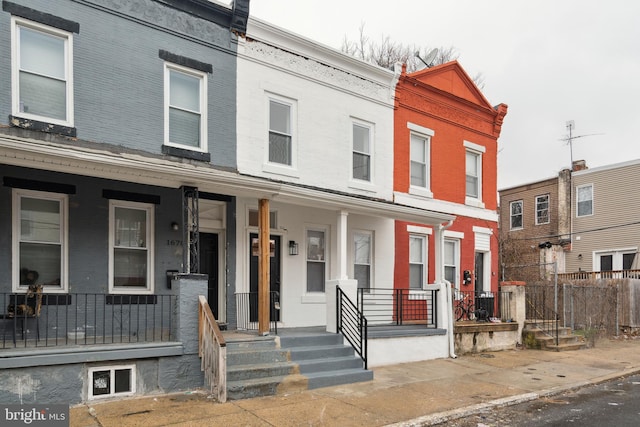 townhome / multi-family property featuring covered porch