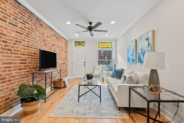 living room with ceiling fan, crown molding, brick wall, and hardwood / wood-style flooring