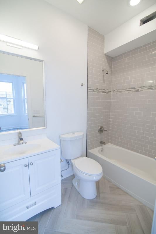 full bathroom featuring vanity, toilet, and tiled shower / bath combo