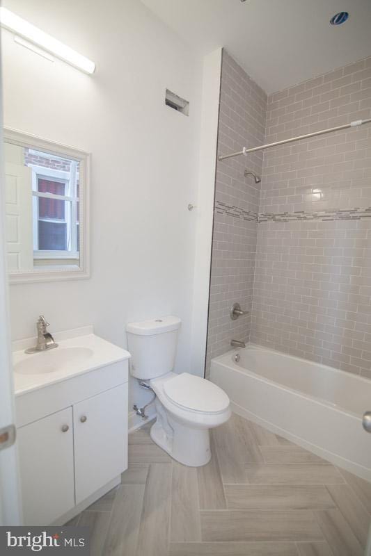 full bathroom with vanity, toilet, and tiled shower / bath