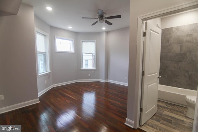 interior space with ceiling fan, shower / bathing tub combination, wood-type flooring, and toilet