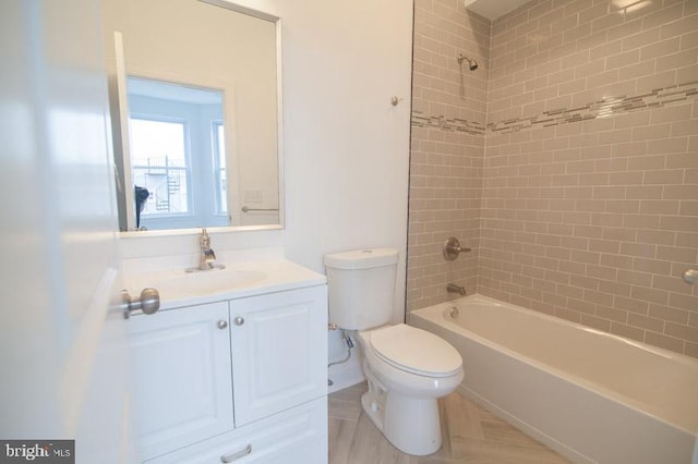 full bathroom with vanity, tiled shower / bath combo, and toilet