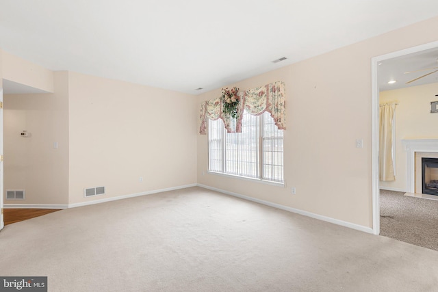 spare room featuring ceiling fan and light colored carpet