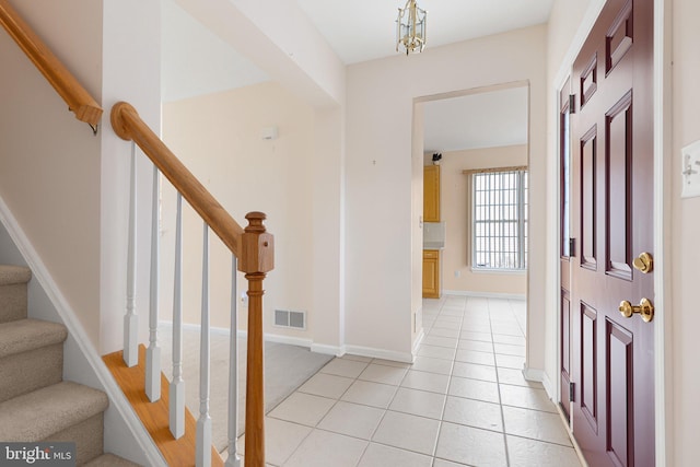 entryway featuring light tile patterned floors and a notable chandelier