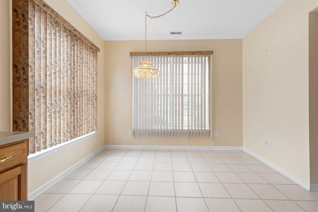 unfurnished dining area featuring a notable chandelier and light tile patterned floors