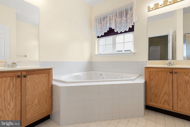 bathroom with tile patterned floors, tiled tub, and vanity