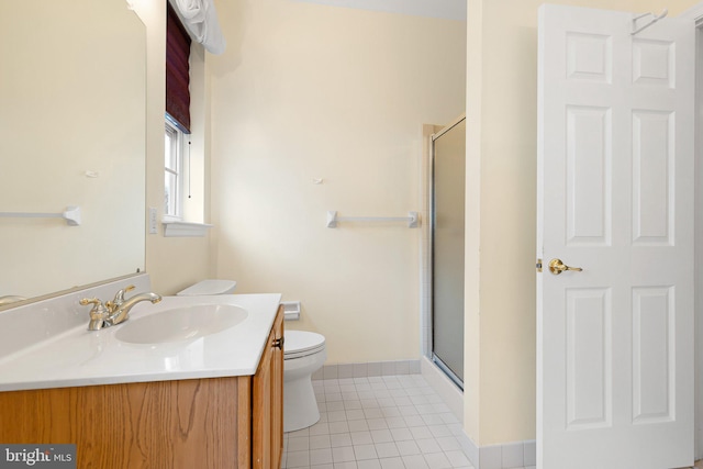 bathroom with tile patterned floors, toilet, vanity, and walk in shower